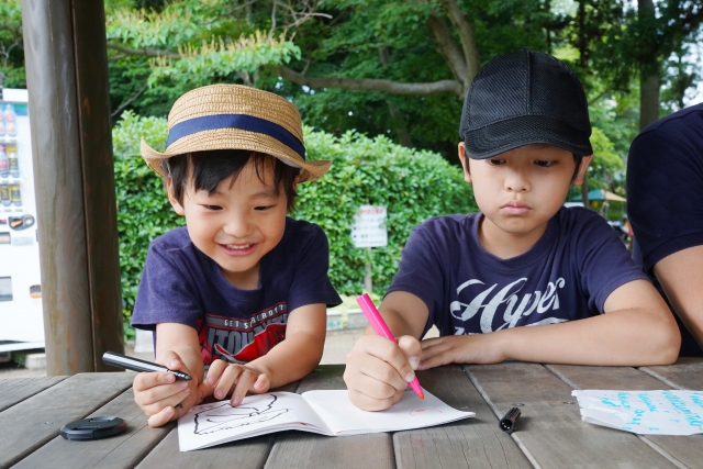 外でお絵描きする子供