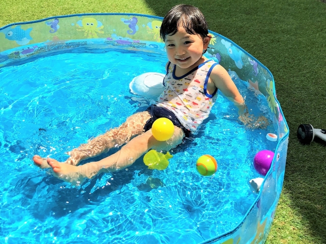 外でプール遊びをする子供